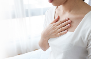 胸を押さえる女性